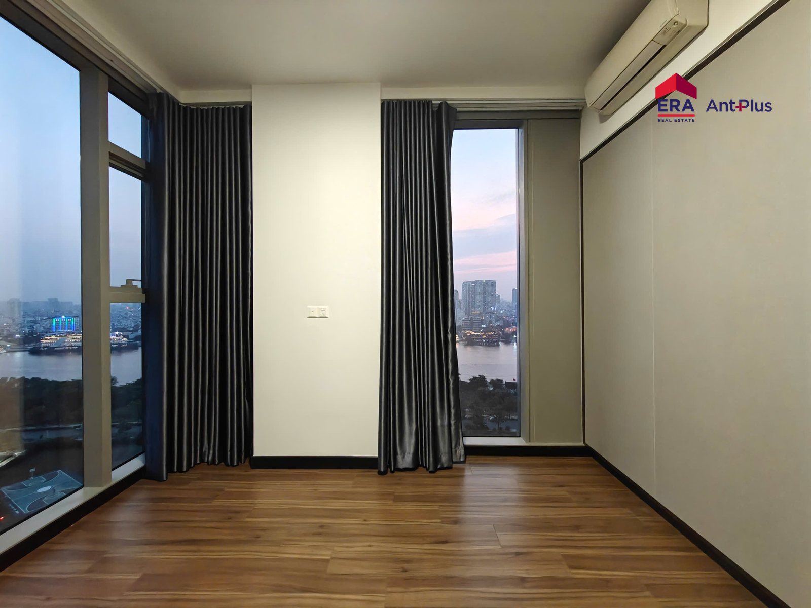 Phòng ngủ góc căn hộ Tilia với cửa kính hai mặt nhìn ra sông