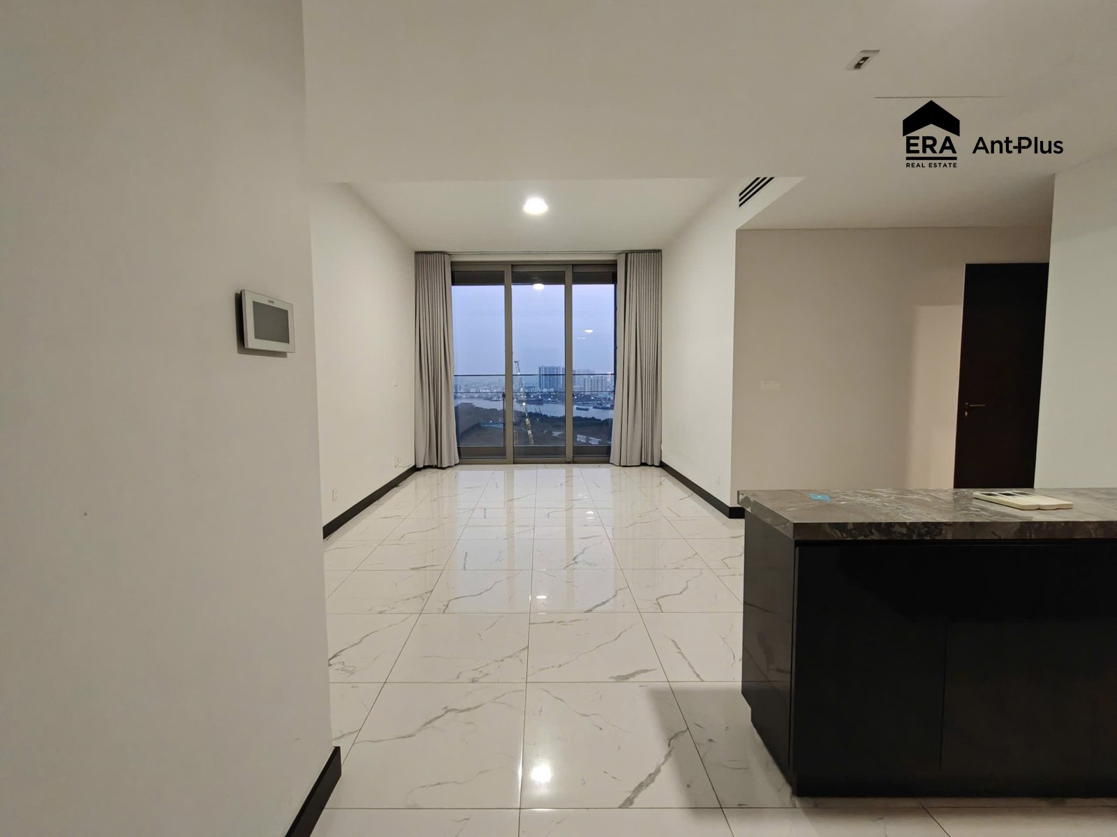 Phòng khách căn hộ Tilia với đảo bếp và cửa kính nhìn ra sông