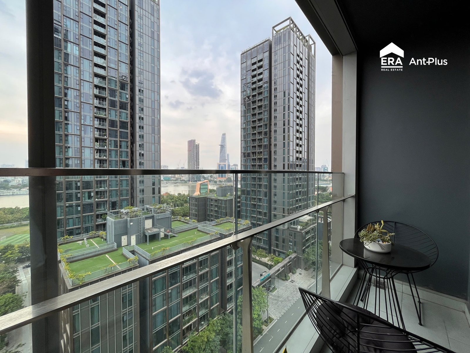 Ban công căn hộ Linden 127m2 với bàn ghế nhìn ra tòa tháp và sông