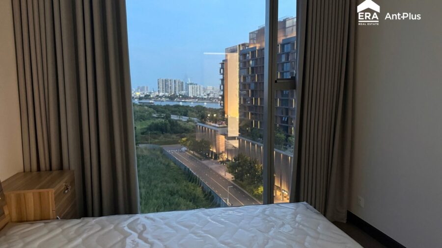 Phòng ngủ căn hộ 1PN Tilia nhìn ra tòa thấp tầng và cây xanh lúc chiều