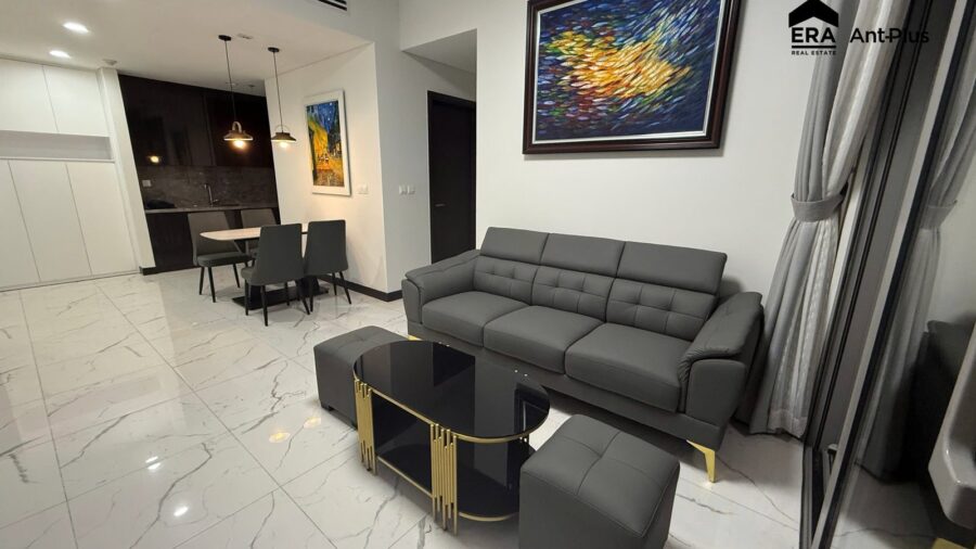 Phòng khách căn hộ thuê 1PN Tilia với sofa xám và tranh sơn dầu