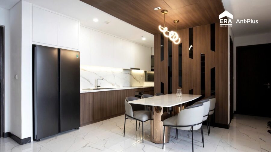 Bàn ăn đá và tủ lạnh đôi cạnh vách gỗ căn hộ Linden