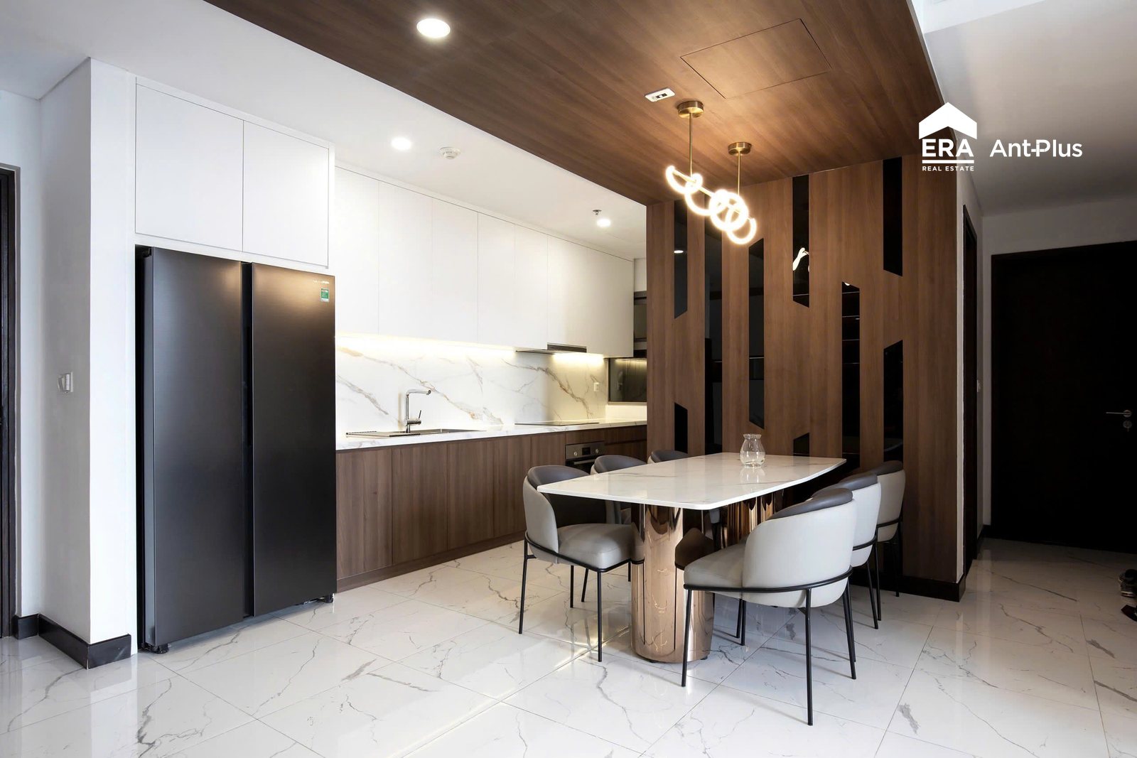 Bàn ăn đá và tủ lạnh đôi cạnh vách gỗ căn hộ Linden
