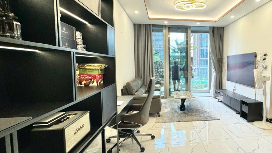 Phòng khách và góc làm việc cạnh tủ kệ đen căn hộ Tilia