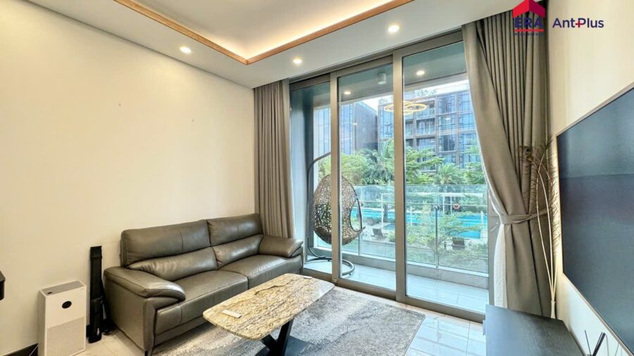 Thuê 2PN Tilia view pháo hoa: phòng khách sofa da và cửa kính nhìn hồ bơi