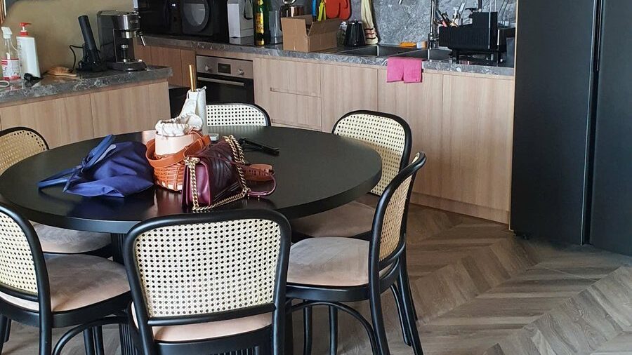 Bàn ăn tròn ghế mây và bếp tủ trắng căn hộ Tilia 98m2