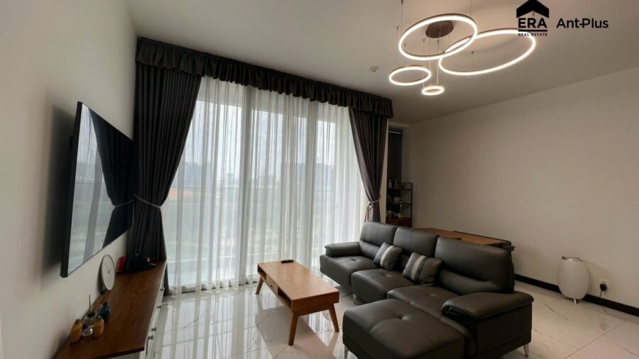 Sofa góc da xám và bàn trà gỗ cạnh cửa kính căn hộ Tilia