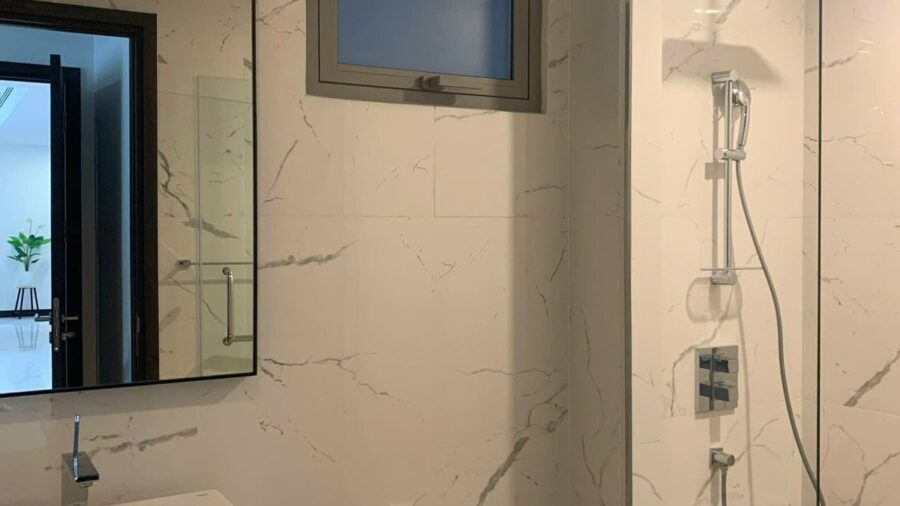 Phòng tắm vách kính và lavabo trắng căn hộ Linden