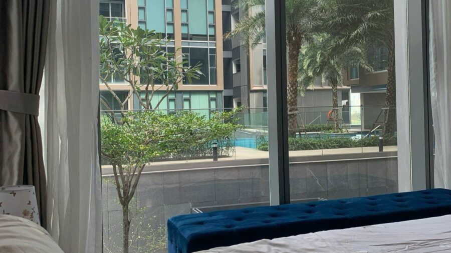Cửa kính phòng ngủ nhìn tòa thấp tầng và cây cọ Empire City