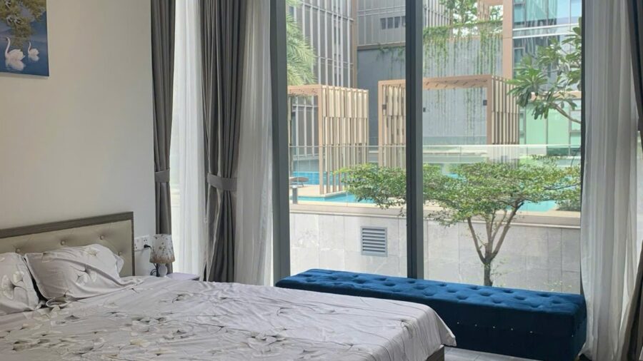 Phòng ngủ thứ hai với ghế băng nhung xanh cạnh cửa kính