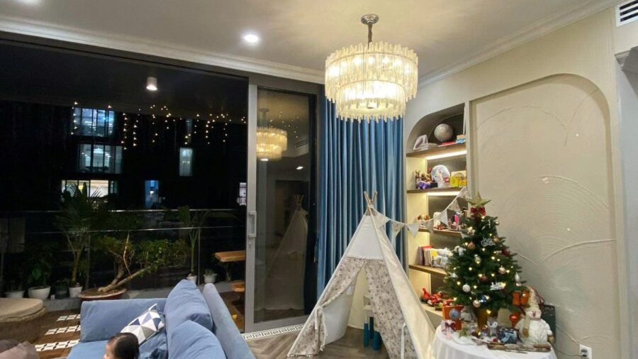 Sofa xanh và cây thông Noel trong phòng khách căn hộ Linden