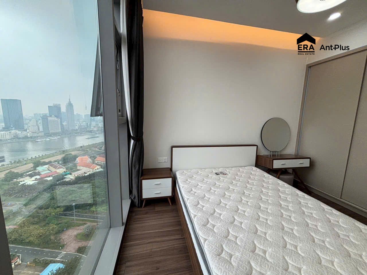 Phòng ngủ phụ căn hộ Linden có bàn trang điểm và view Quận 1