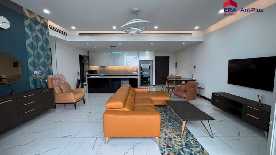 Phòng khách rộng căn hộ Linden với sofa cam và TV treo tường