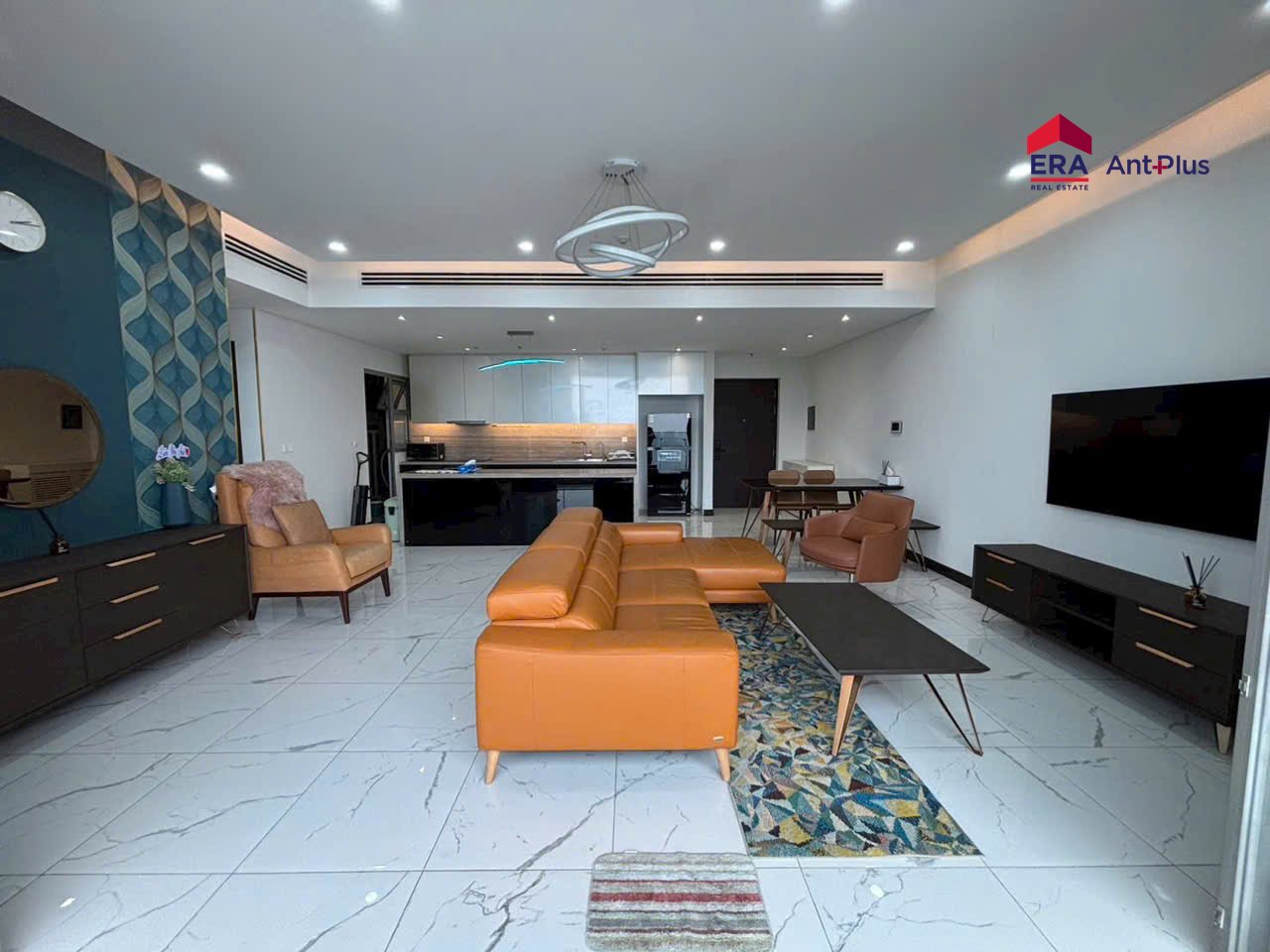 Phòng khách rộng căn hộ Linden với sofa cam và TV treo tường