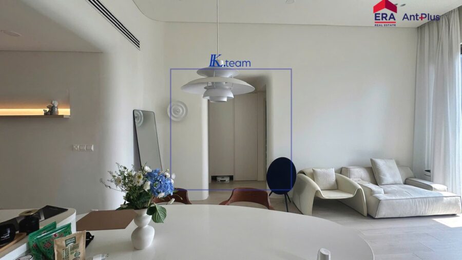 Bàn ăn trắng, đèn thả và sofa trong căn hộ Tilia trần cao