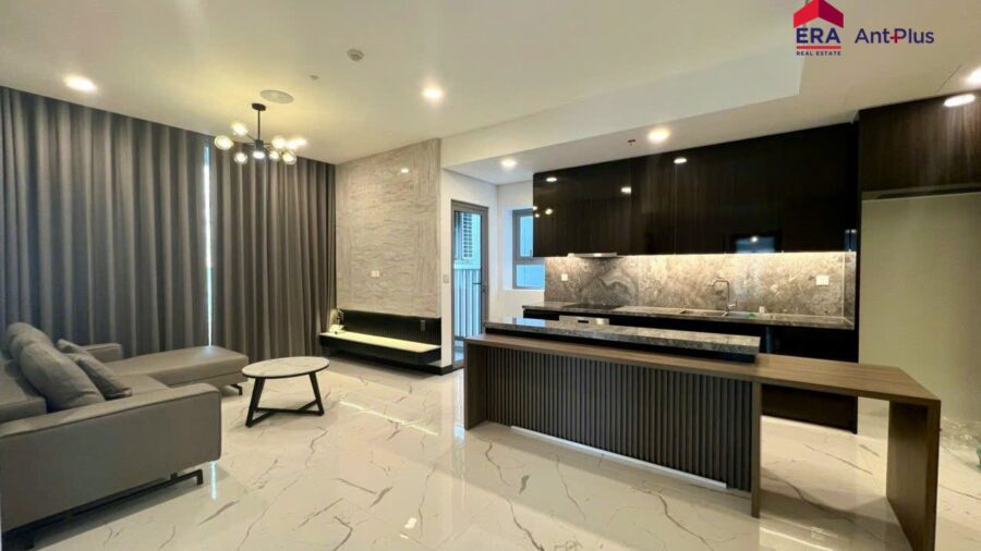 Thuê 2PN Tilia view sông Quận 7: phòng khách sofa xám và đảo bếp ốp lam gỗ